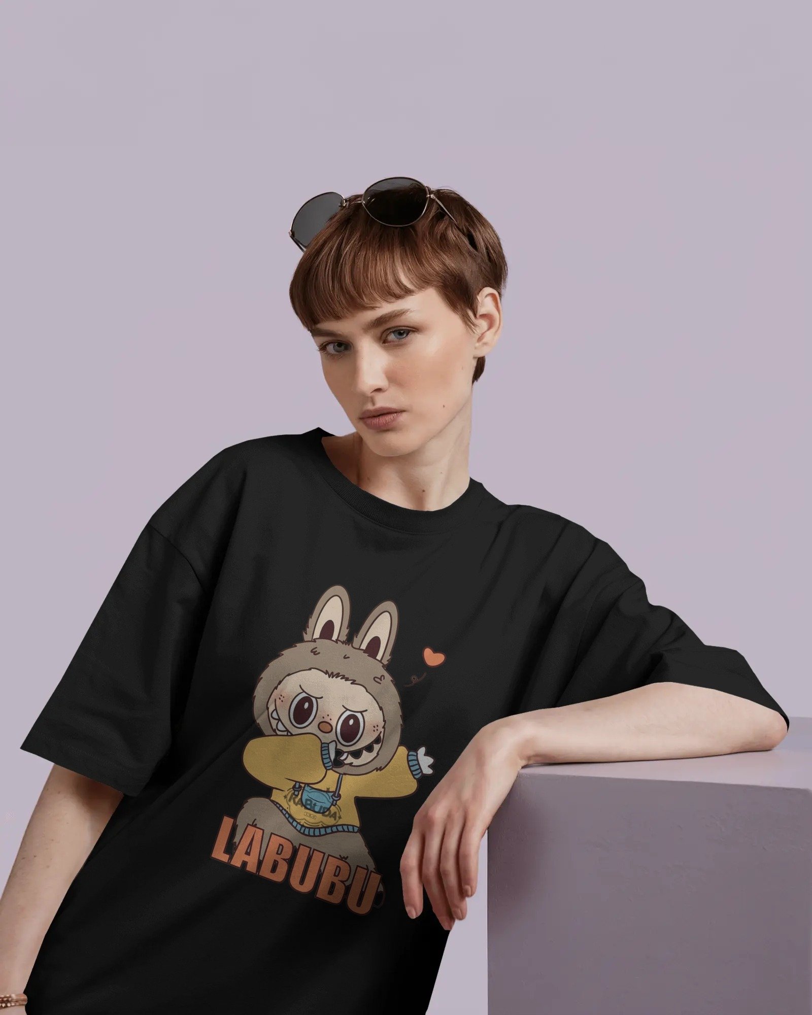 oversized-white-tshirt-mockup-female-model-short-hair-sunglasses-on-head-leaning-on-purple-block-01074